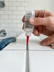 Applying grout sealer to bathroom tile joints.