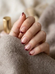 Short sheer nails with deep red French tips